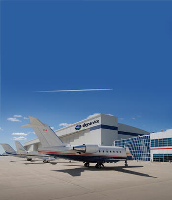 The outside of the Skyservice building with a business jet in front